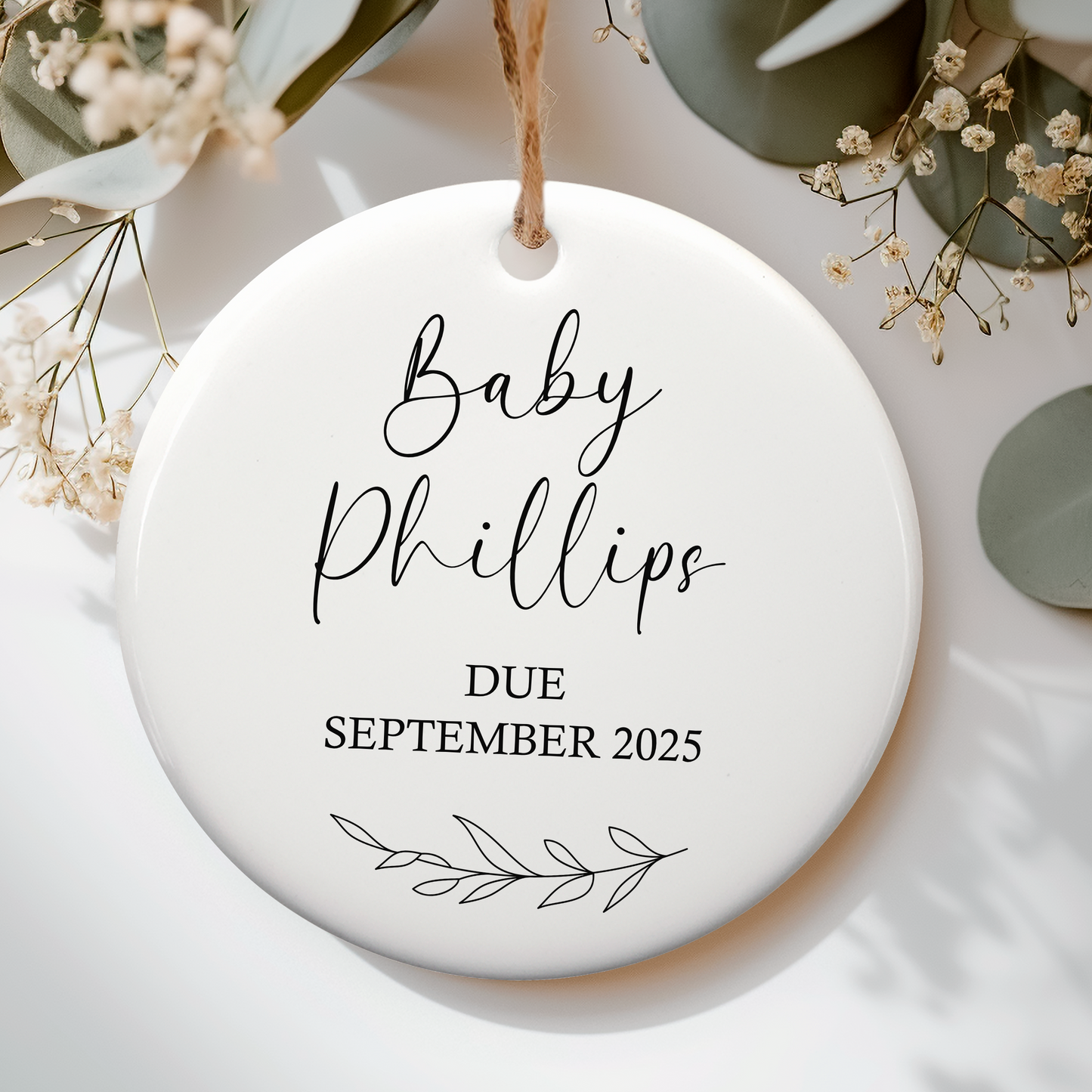 a white ceramic ornament with a baby's name on it