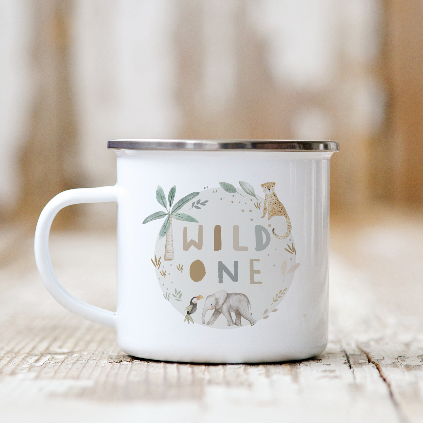 a white enamel mug with the words wild one printed on it, jungle safari animals illustrated around a beige circle