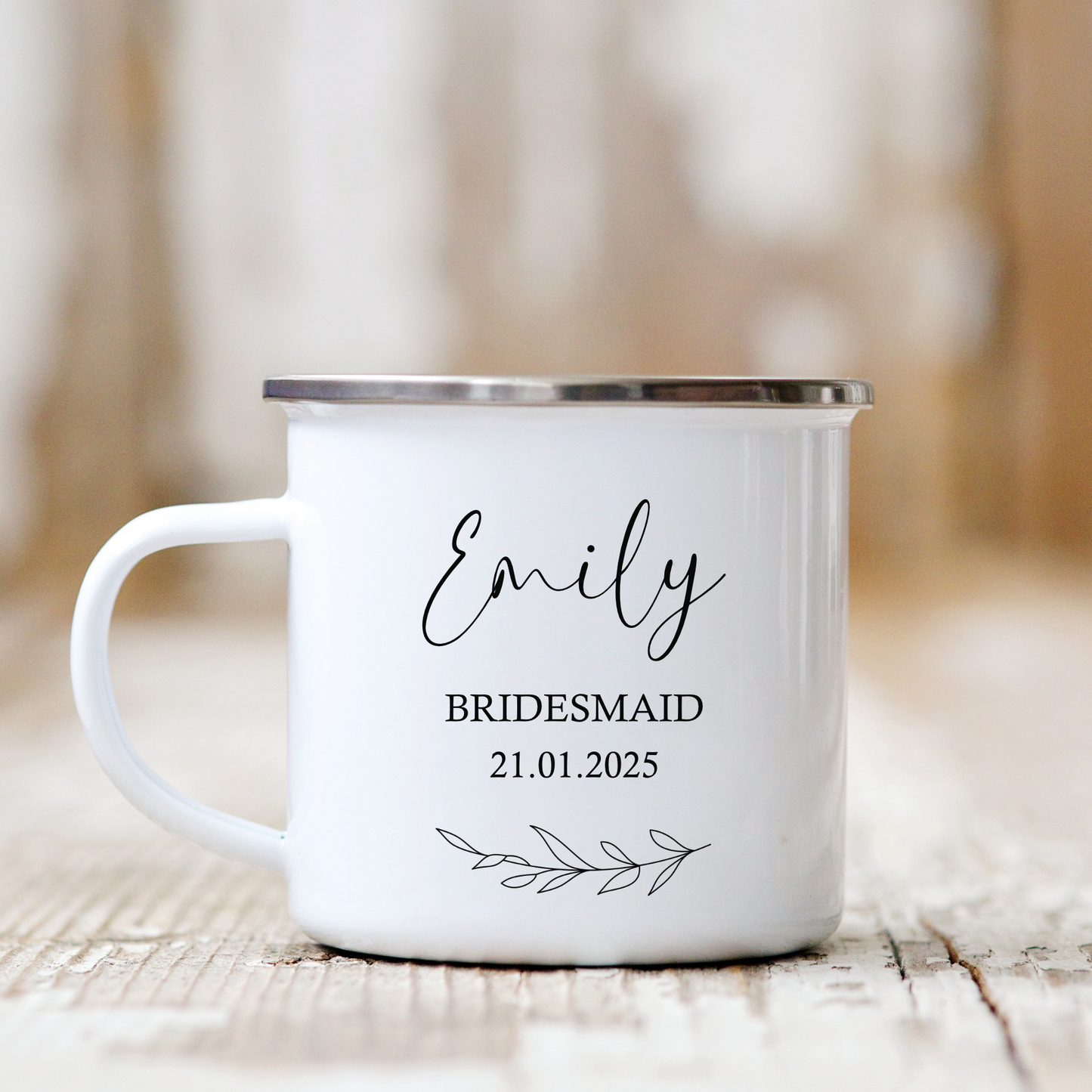 a white enamel coffee mug with name and bridesmaid and date of wedding on, laurel leaf motif underneath