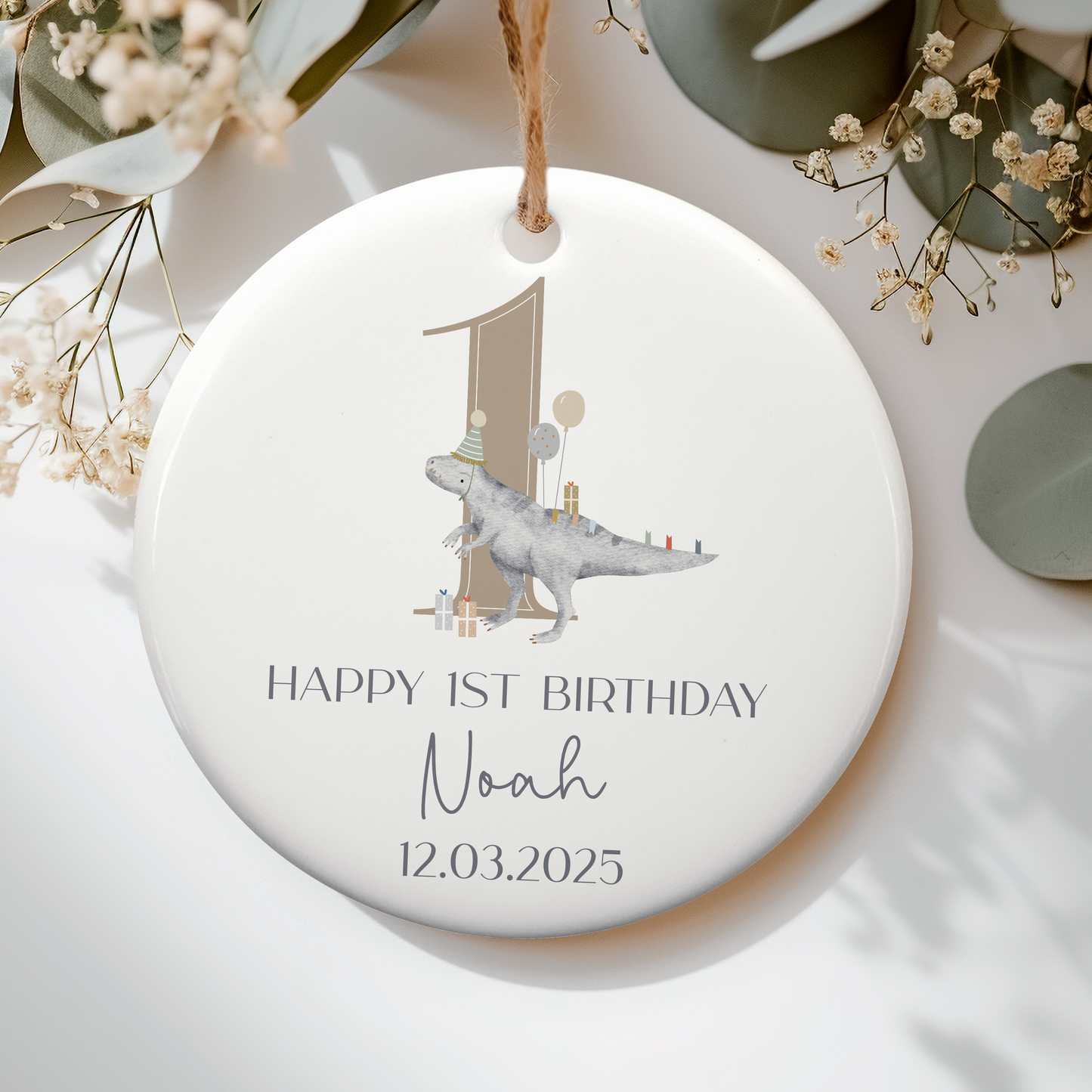 a white ceramic ornament with a dinosaur with party balloons on it. Personalised with name and date