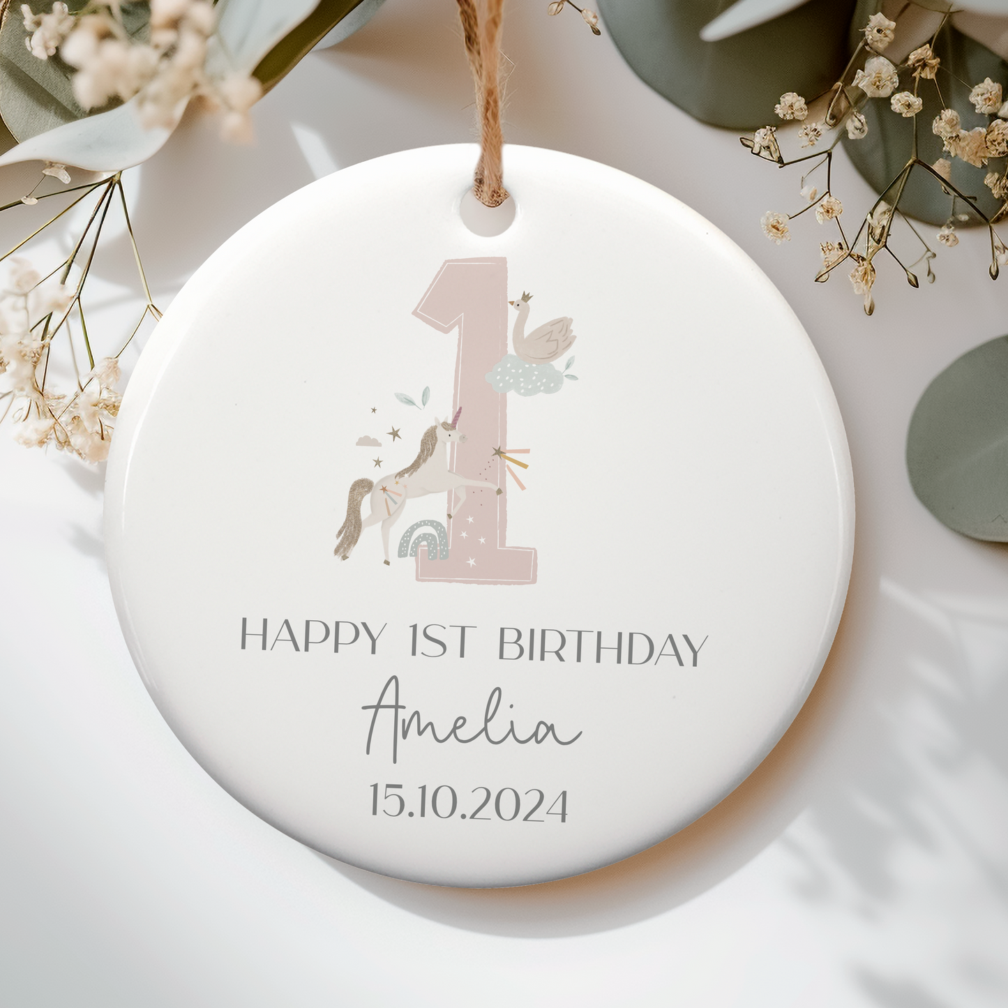 a first birthday ornament with a magical unicor around a pink number 1. Personalised with name and date
