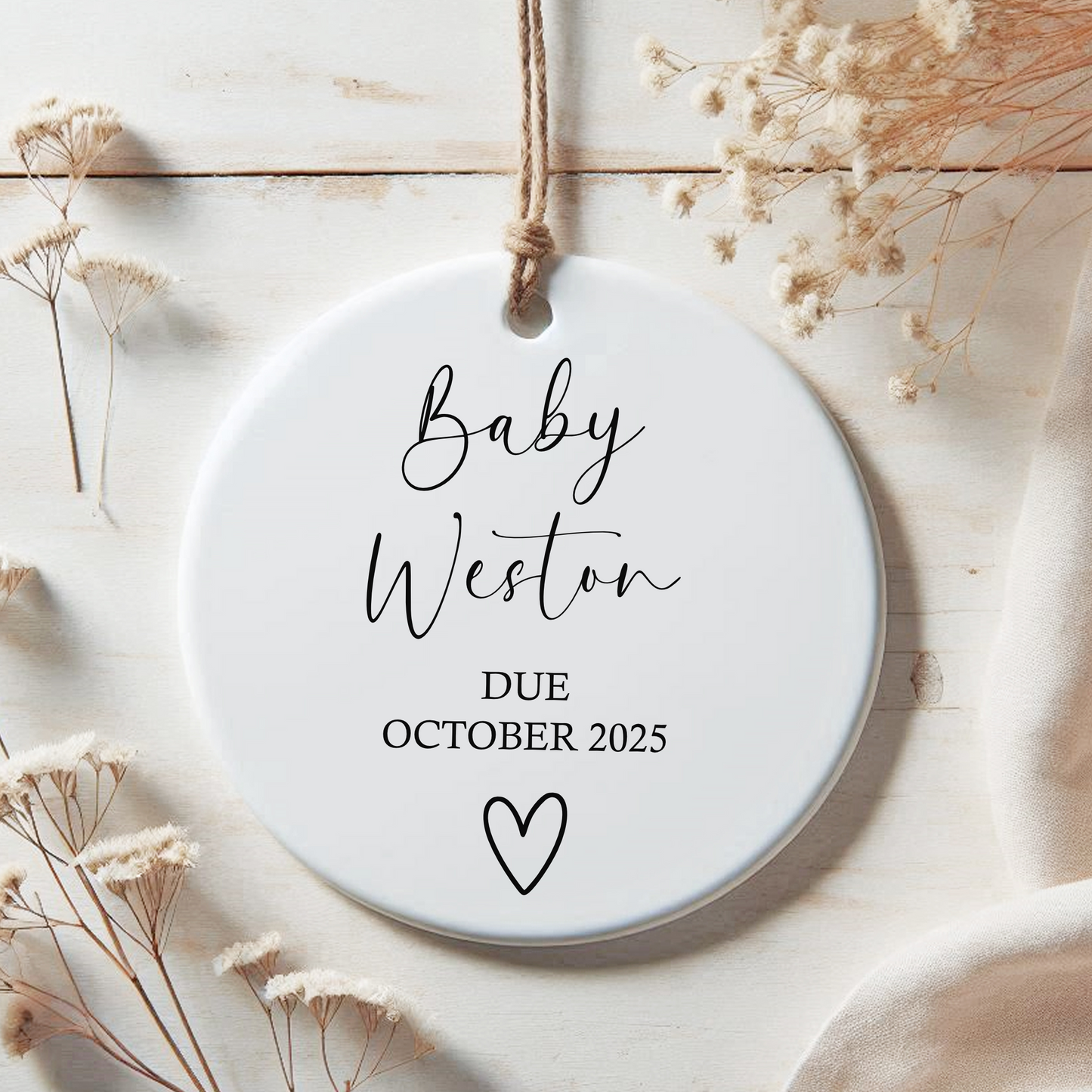 a white ceramic ornament with a baby's name on it
