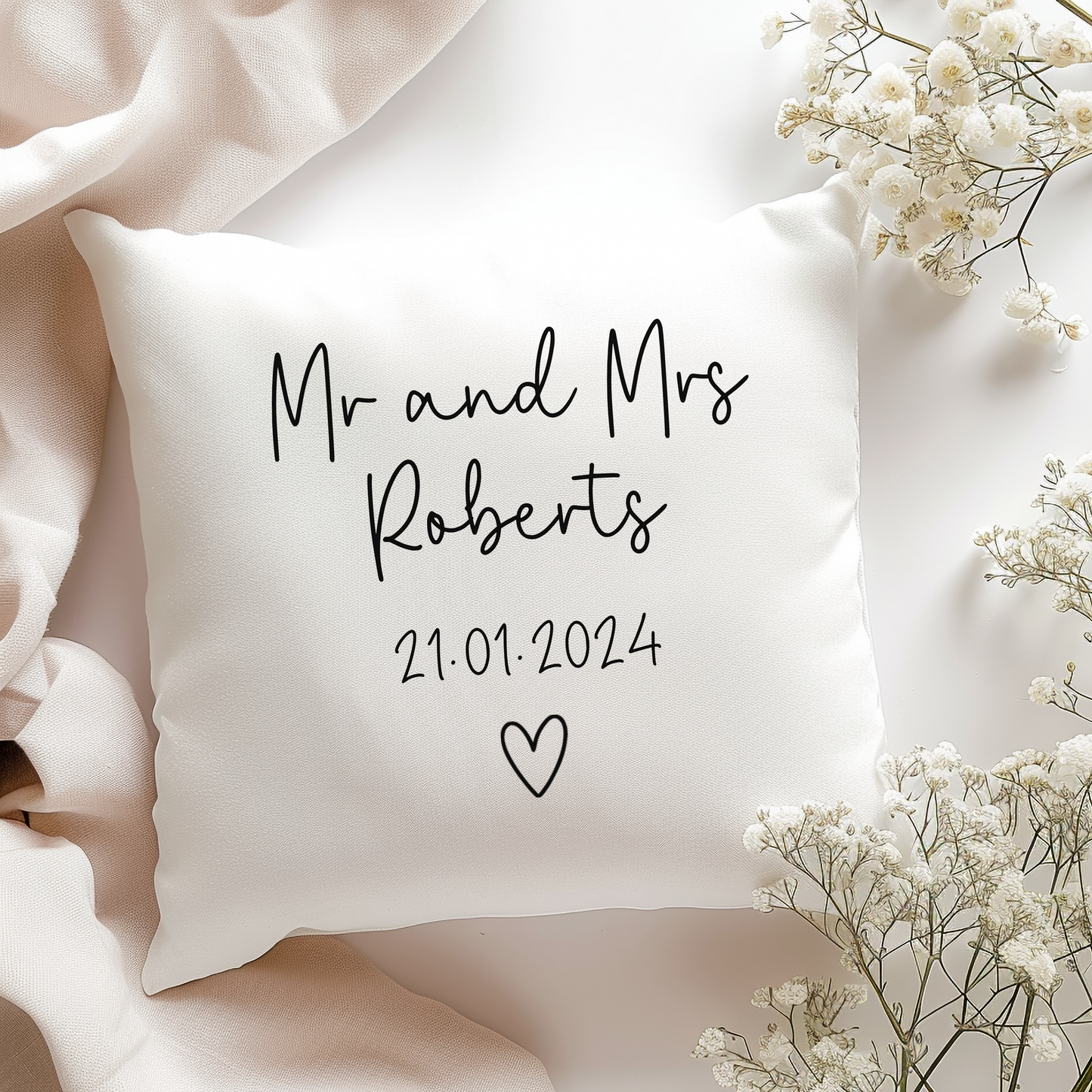 a white pillow personalied with wedding couple name and wedding date with heart doodle underneath