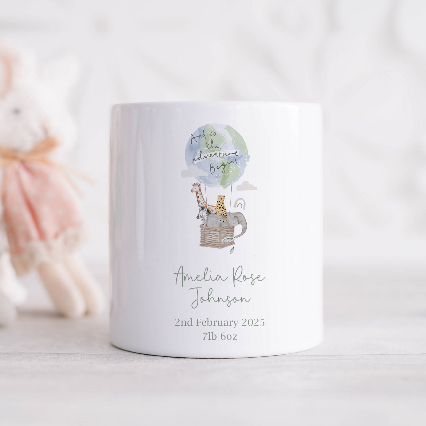 a white ceramic money box with a picture of a giraffe and jungle animals in a hot air balloon. Personalised with baby birth details