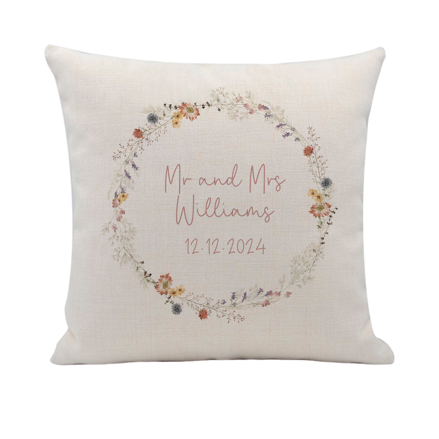 a white pillow with a floral wreath on it