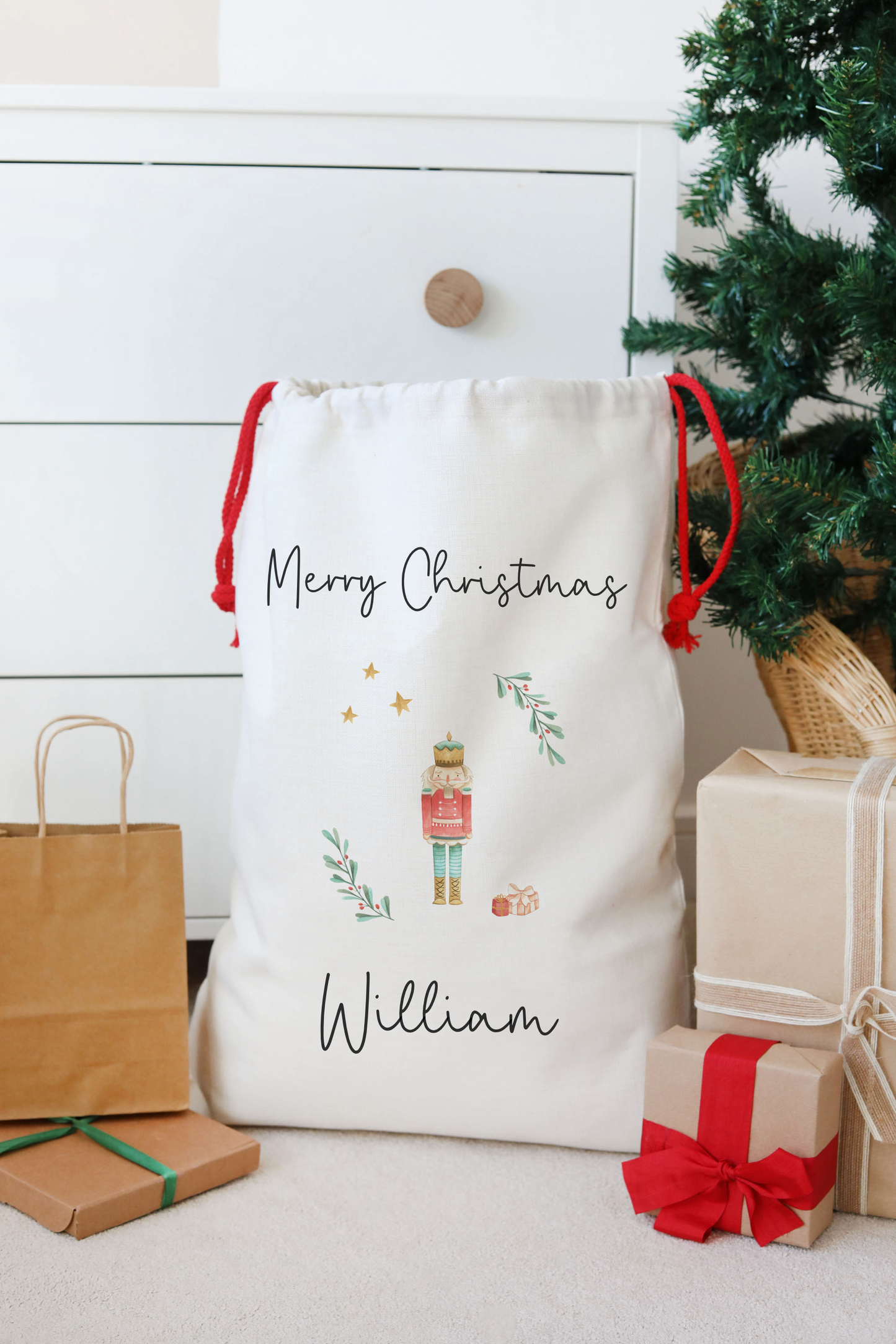 Personalized Christmas gift bag with 'Merry Christmas' and a nutcracker design, surrounded by presents and a tree.