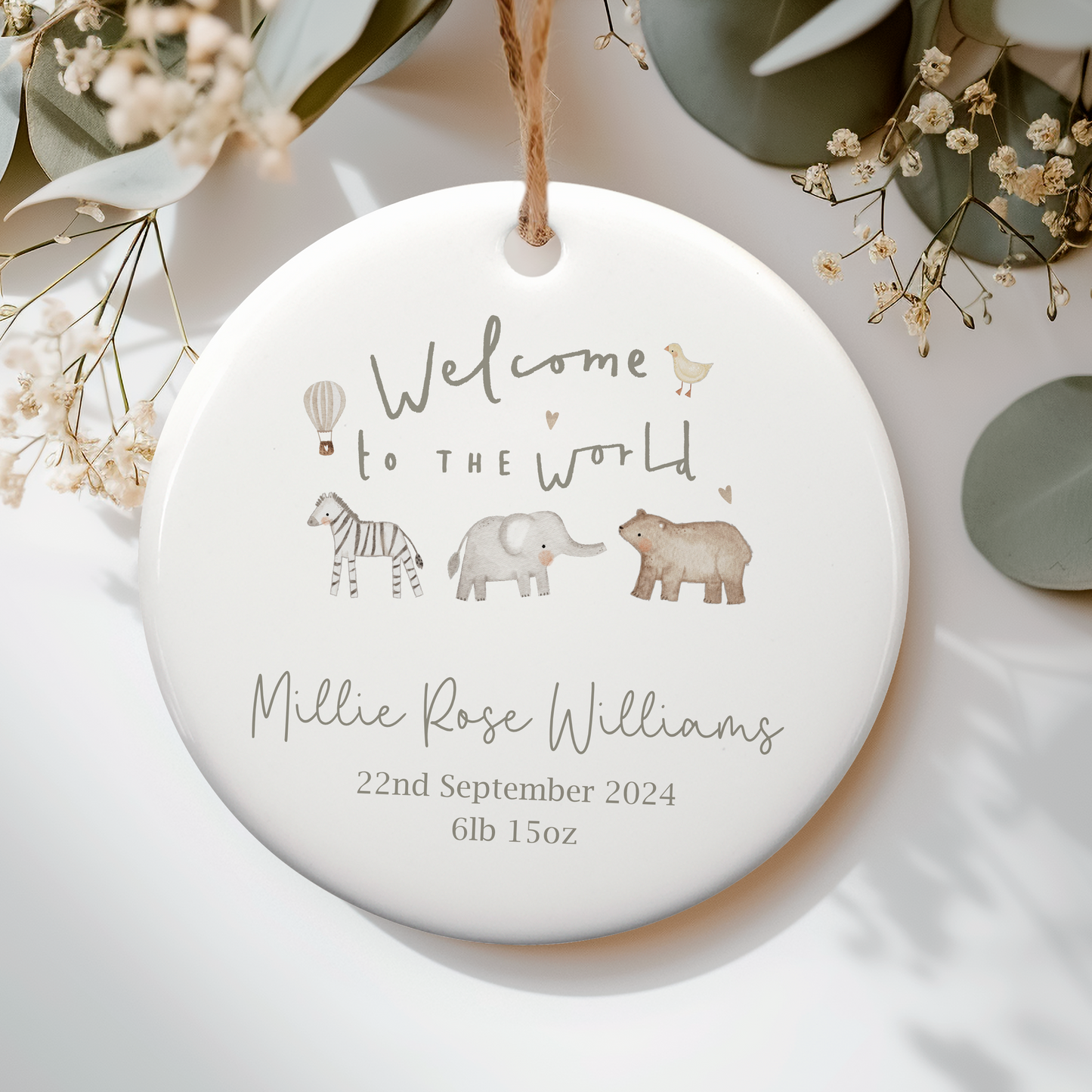 a ceramic ornament with a baby's name and a picture of elephants, text with welcome to the world. Personalised with name and birth details