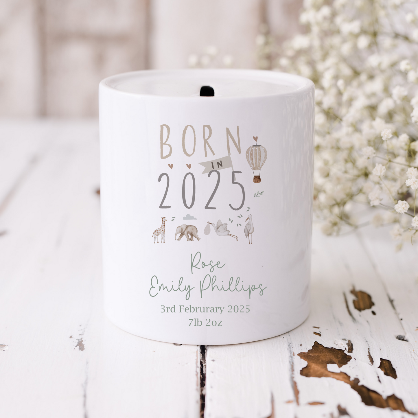 white ceramic money box with Born in 2025 text. Jungle, safari animals illustration. Personalised with name and birth details in green font.