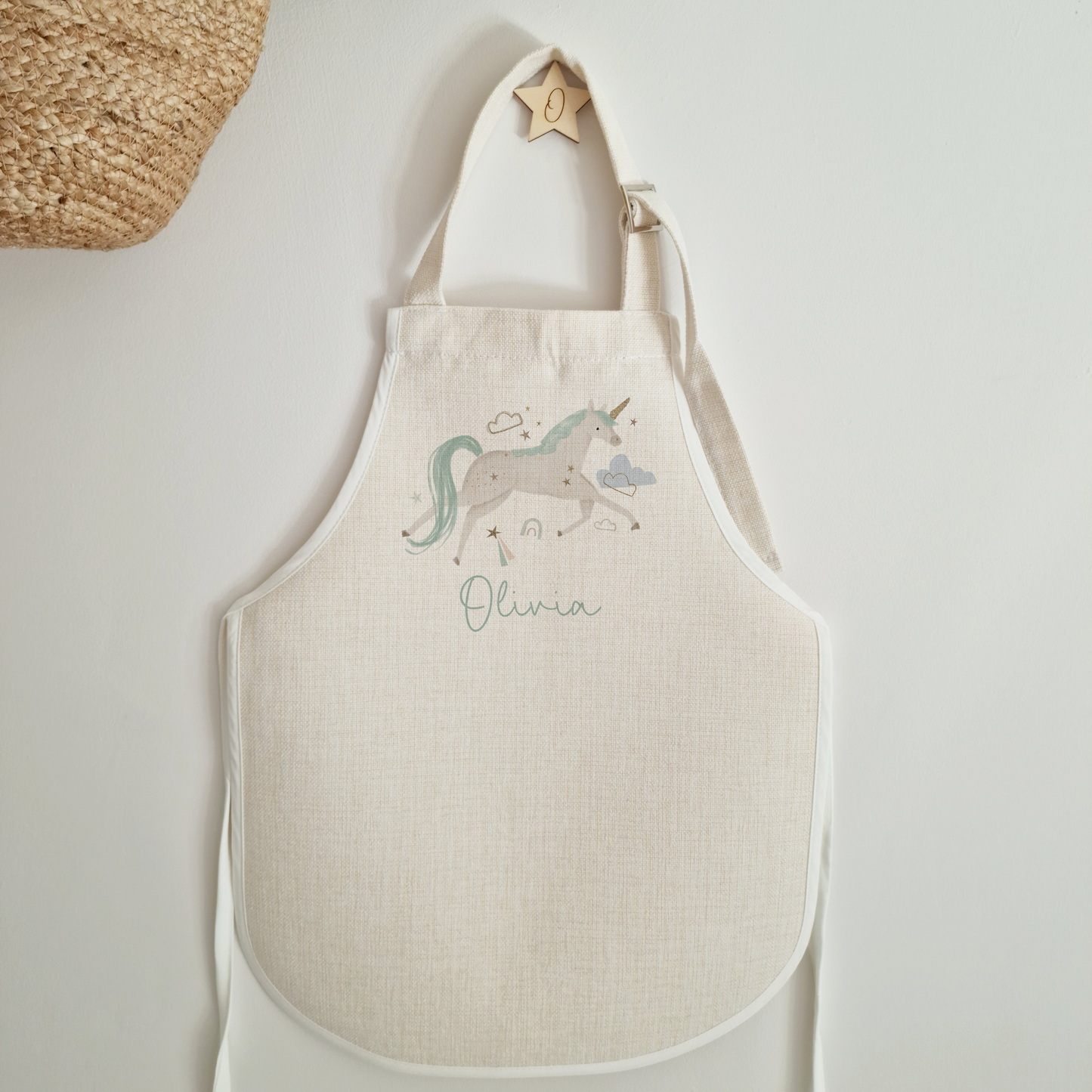 off white apron with magical unicorn on, personalised with name in mint font