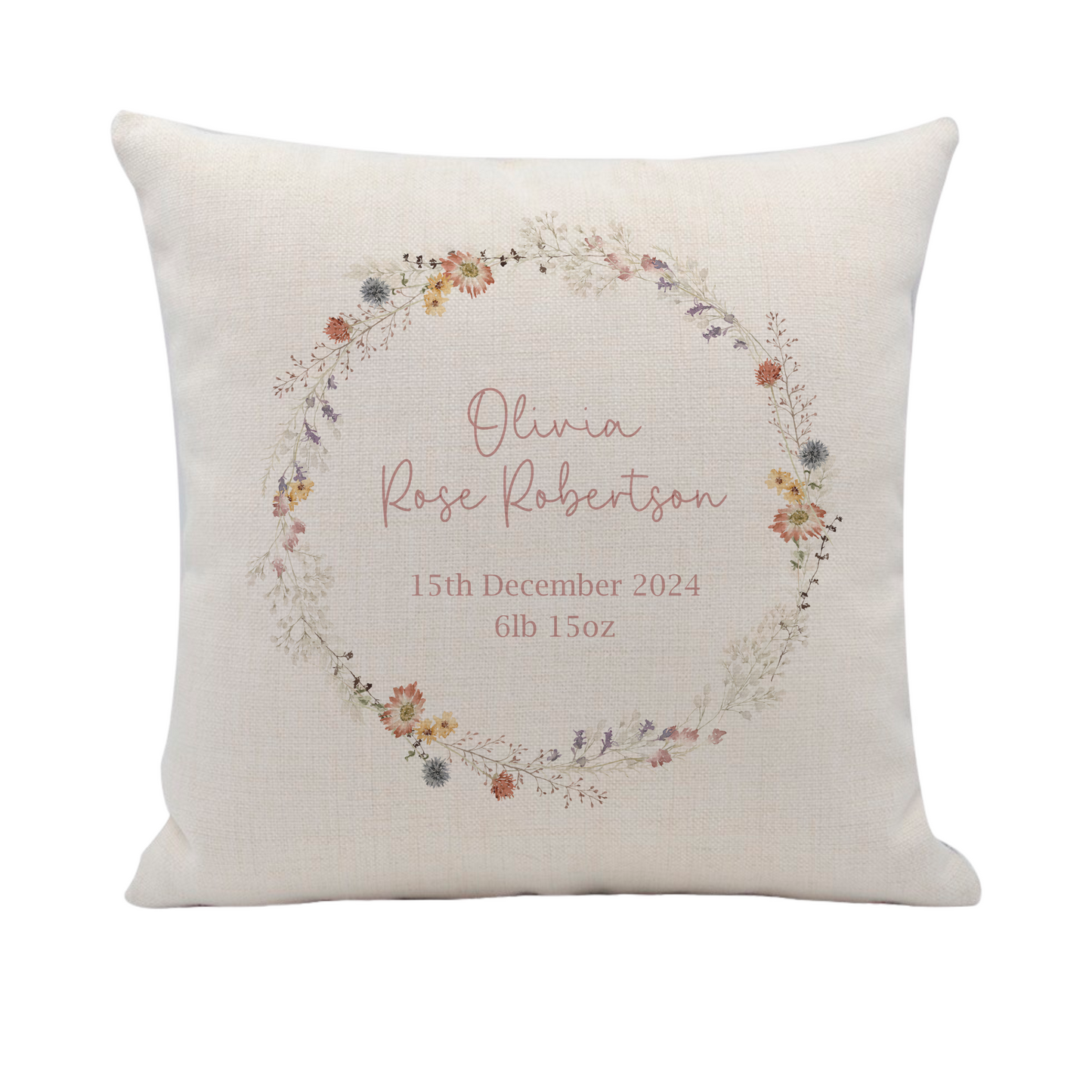 a white pillow with a floral wreath on it
