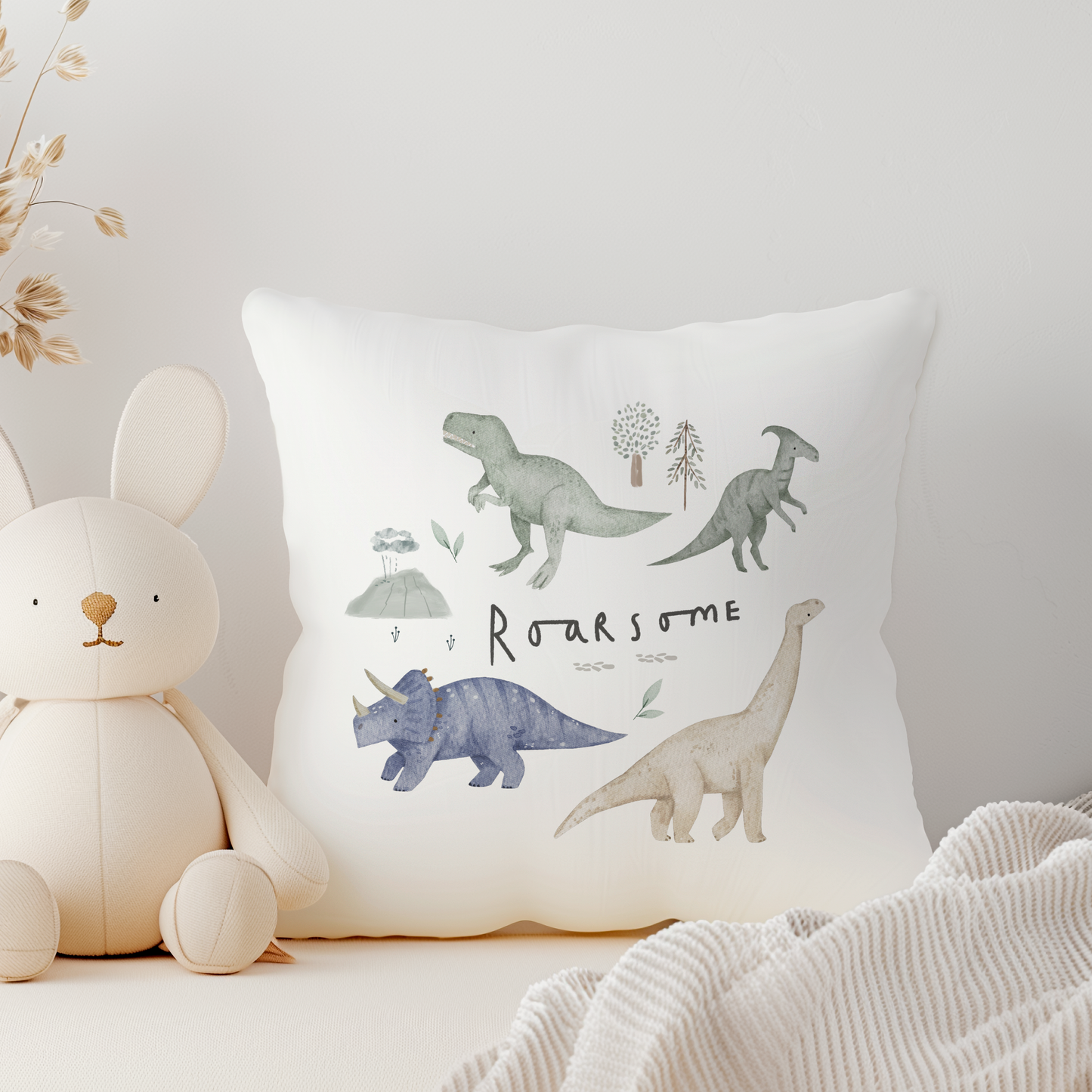 White canvas cushion cover with green dinosaurs and Roarsome text