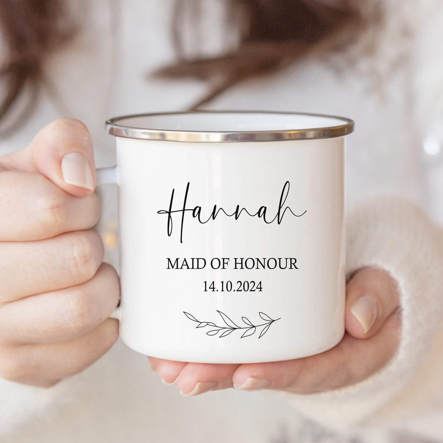 a woman holding a white mug with a name on it