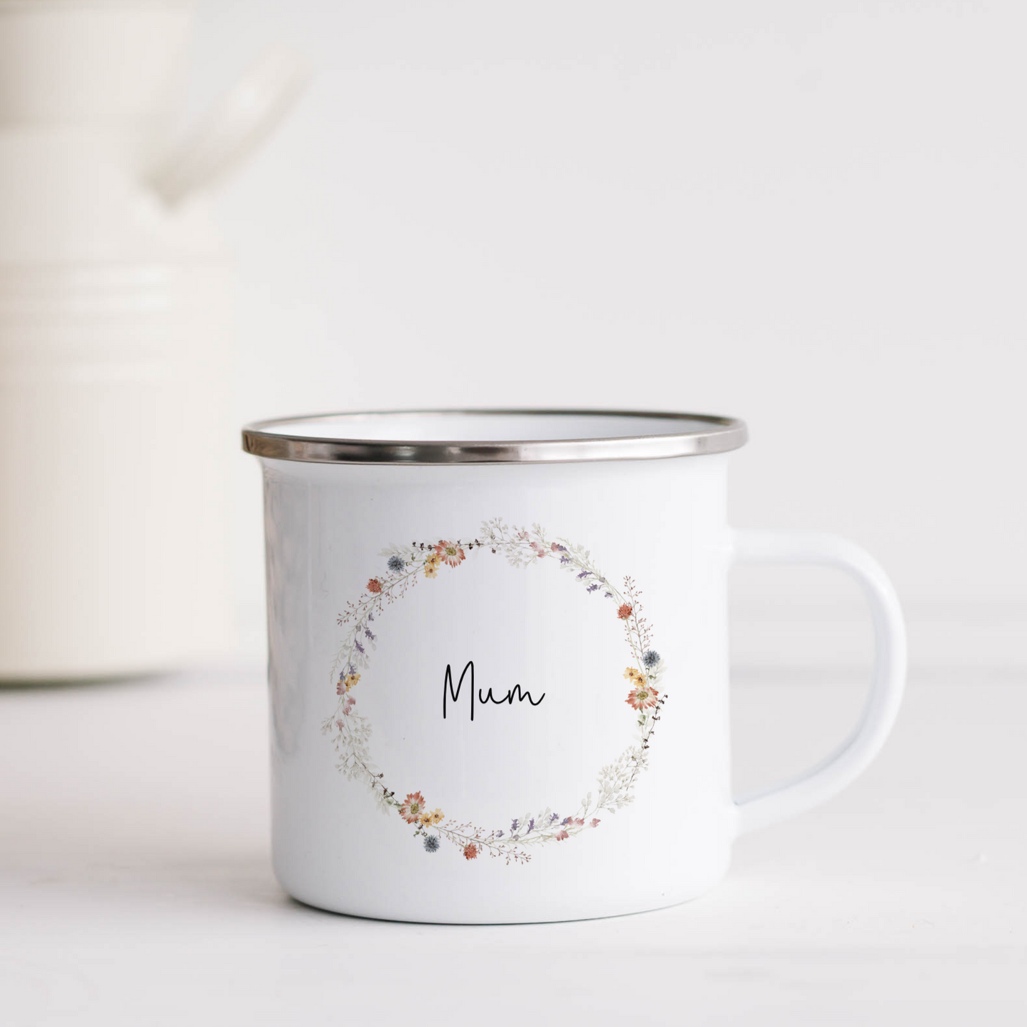 White enamel mug with wildflower wreath and mum text in black script font.