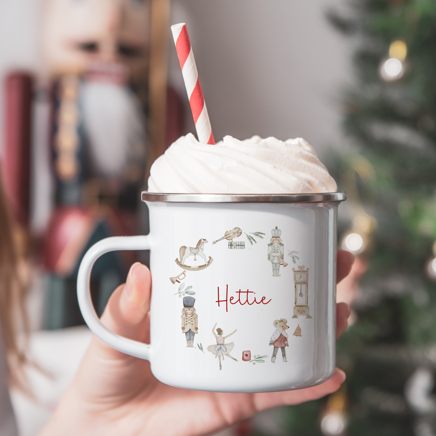 12oz white enamel mug with Traditional Christmas illustration wreath including The Nutcracker and Sugar Plum Fairy. Personalised with name in red script font.