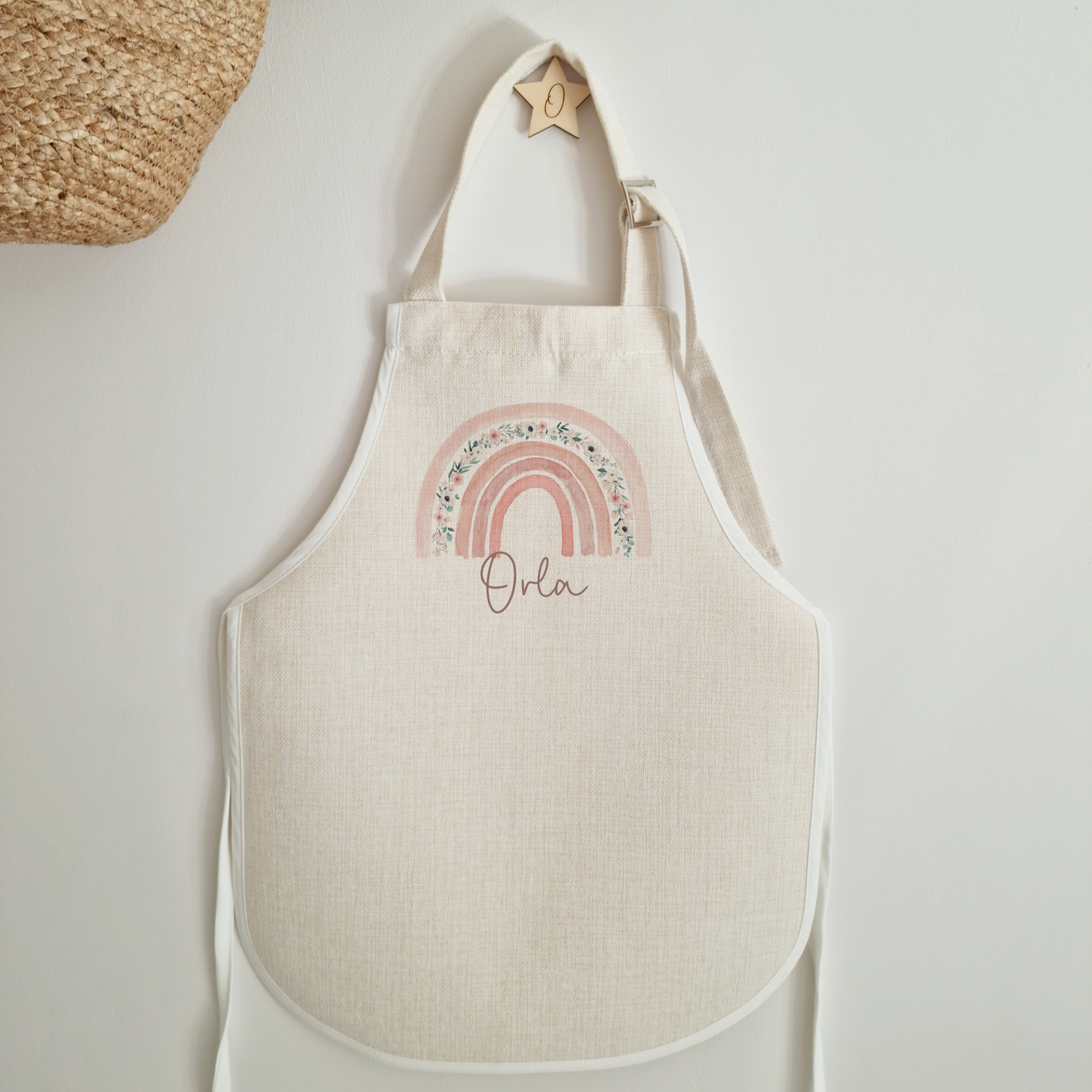 Off white linen like childs apron. With Pink boho floral rainbow and personalised with name.