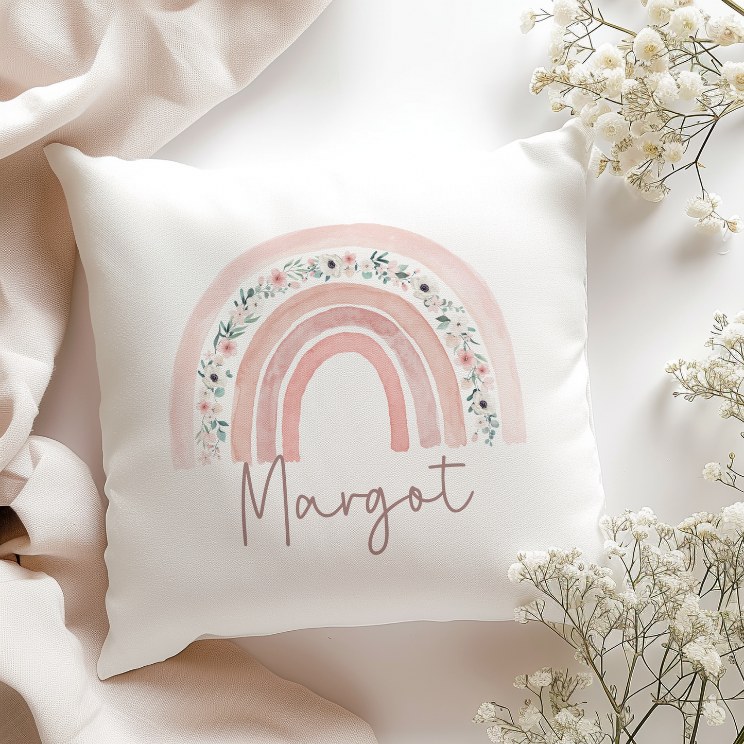 White cushion with boho pink floral rainbow, personalised with name in script font.