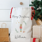 Personalized Christmas gift bag with 'Merry Christmas' and a nutcracker design, surrounded by presents and a tree.