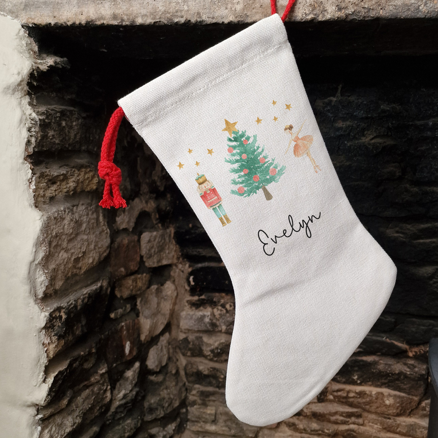 Off white linen-like stocking with The Nutcracker and Sugar Plum Fairy illustration. Personalised with name in black script font.