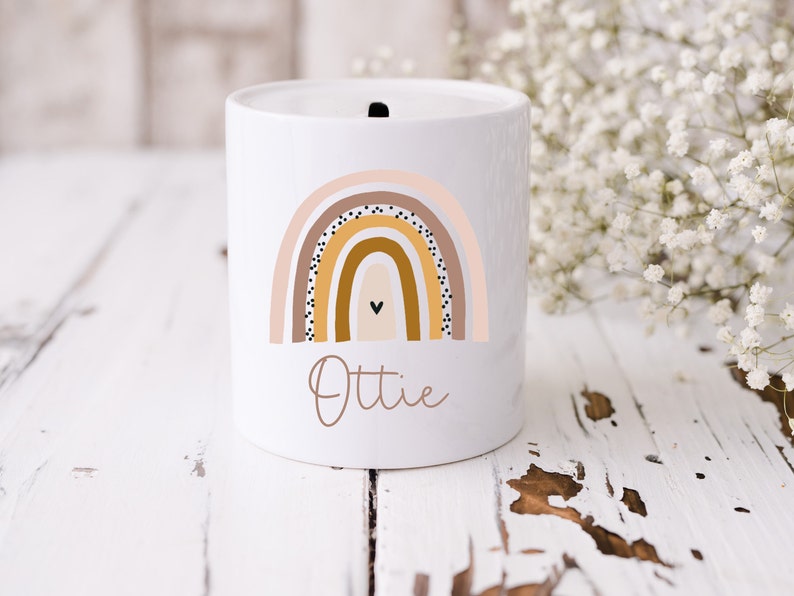 White ceramic money box with boho rainbow  in muted tones. Personalised with name.