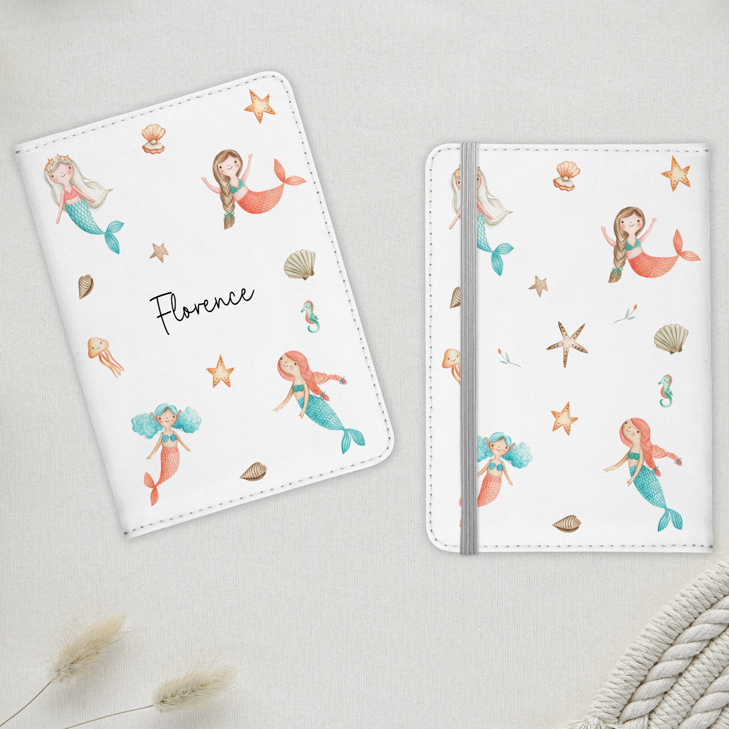 Two white passport covers with mermaid design, personalised with name