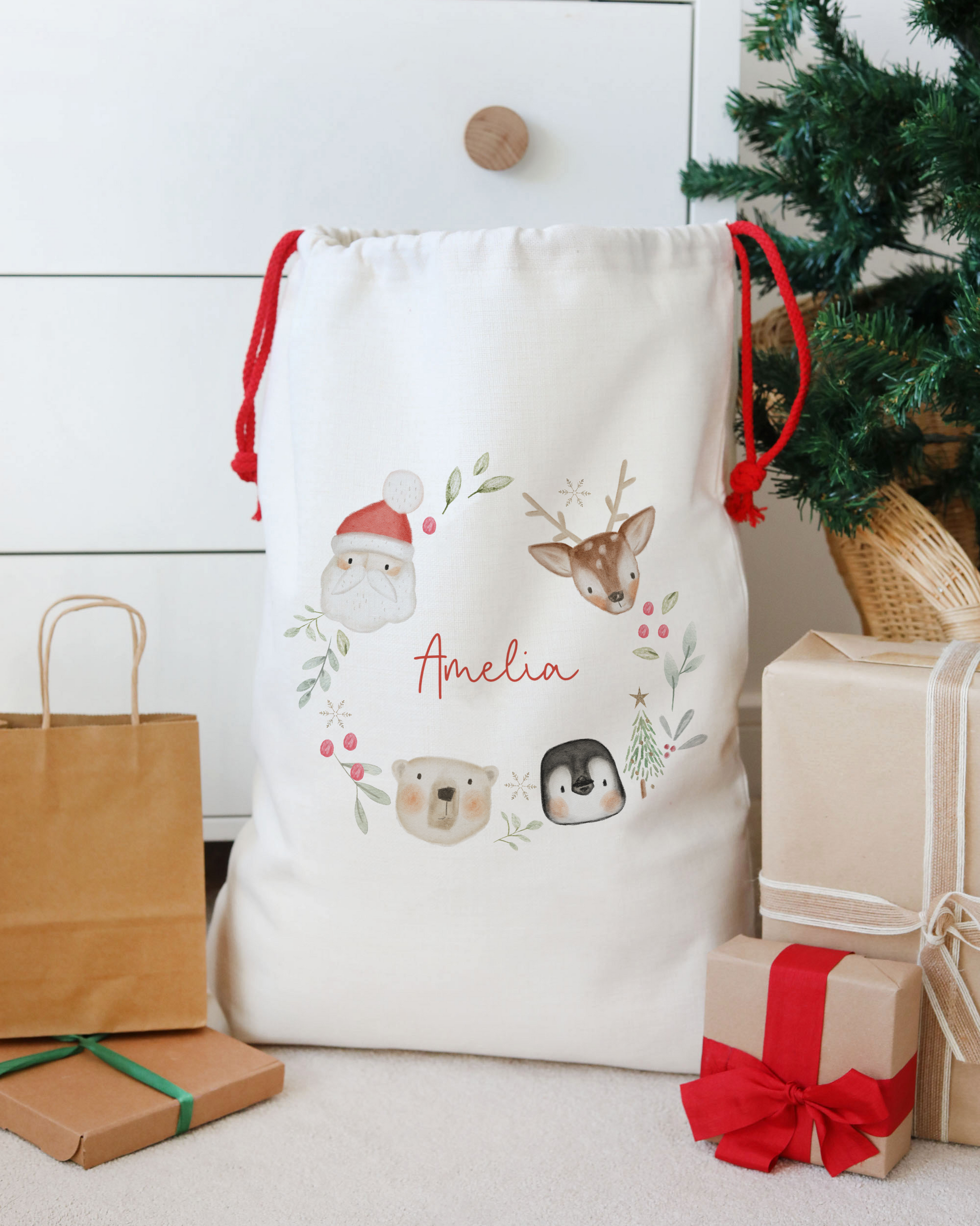 White drawstring bag with festive designs and 'Amelia' text, surrounded by Christmas presents and decorations.