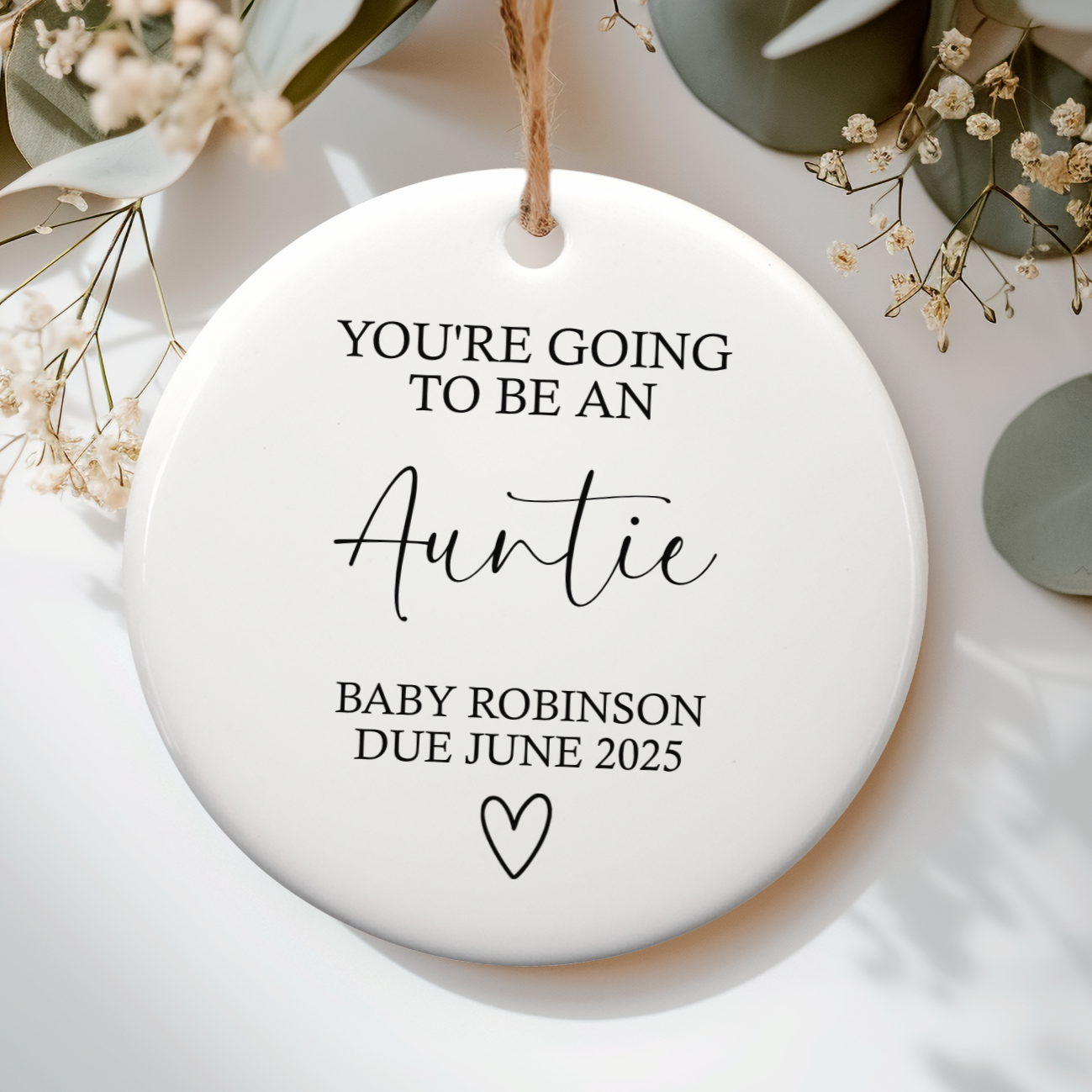 White ceramic ornament with the text "you're going to be an auntie" and baby's due details, with cute heart doodle underneath.