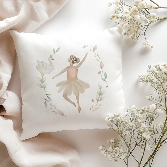 Decorative pillow with a ballerina and swan design, surrounded by white flowers on a soft pink fabric background.