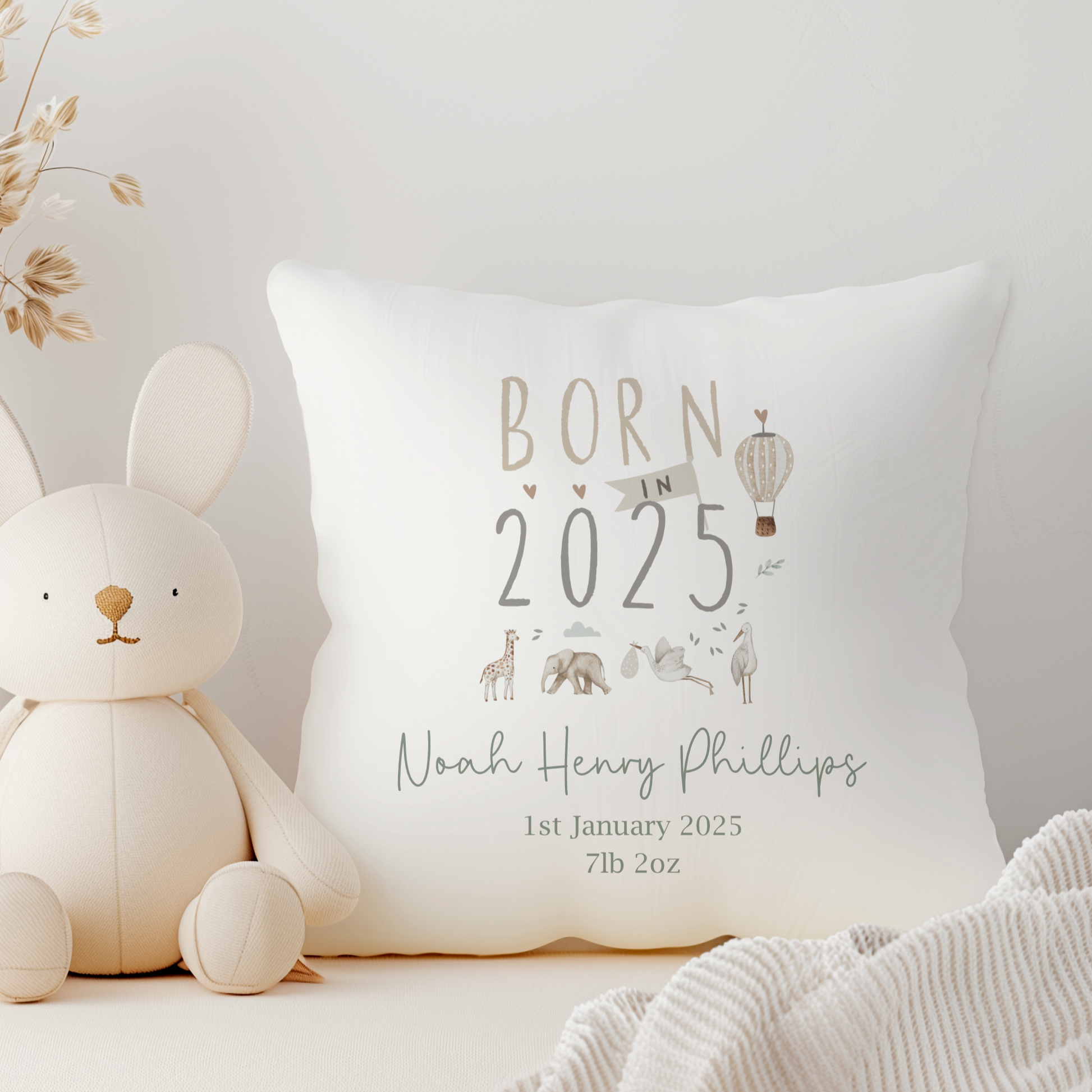 White cushion cover with Born in 2025 text. Jungle Safari Animals illustration. Personalised with name, birth date and birth weight in green font.