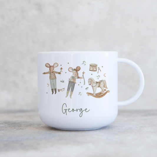 White mug with illustrations of nutcracker style festive mice and the name 'George' on a light gray background