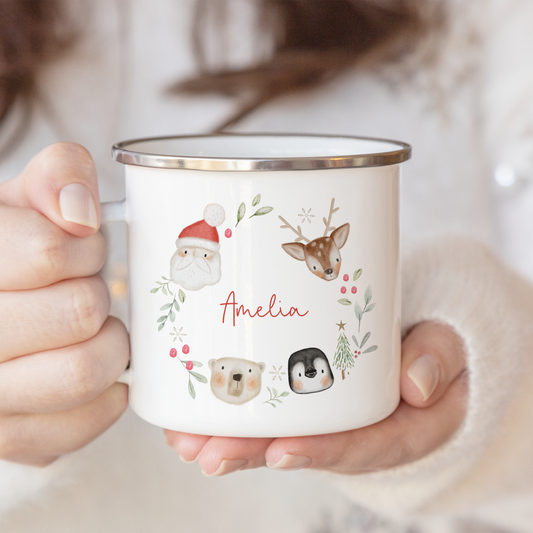 Person holding a mug with festive animals, santa claus designs and 'Amelia' printed on it.