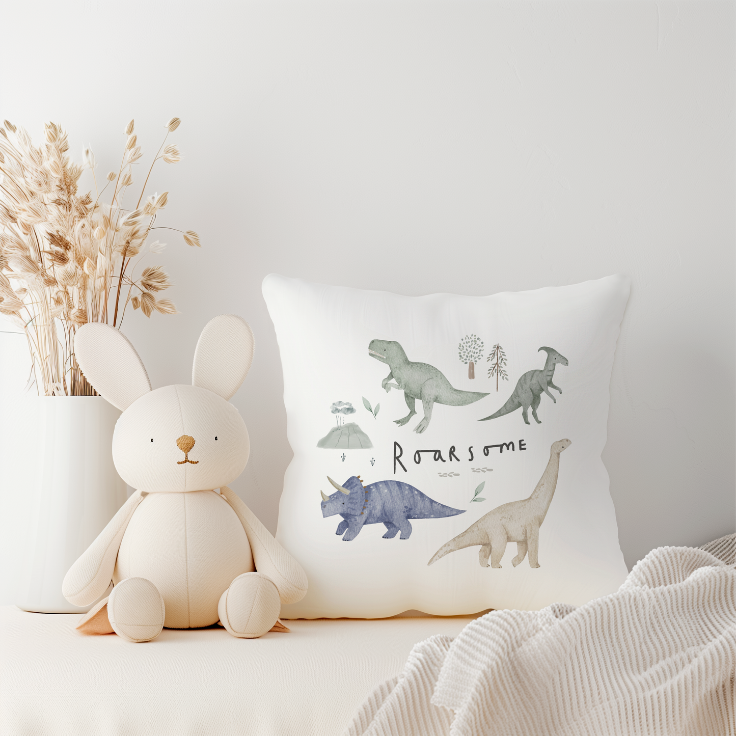 White canvas cushion cover with green dinosaurs and Roarsome text