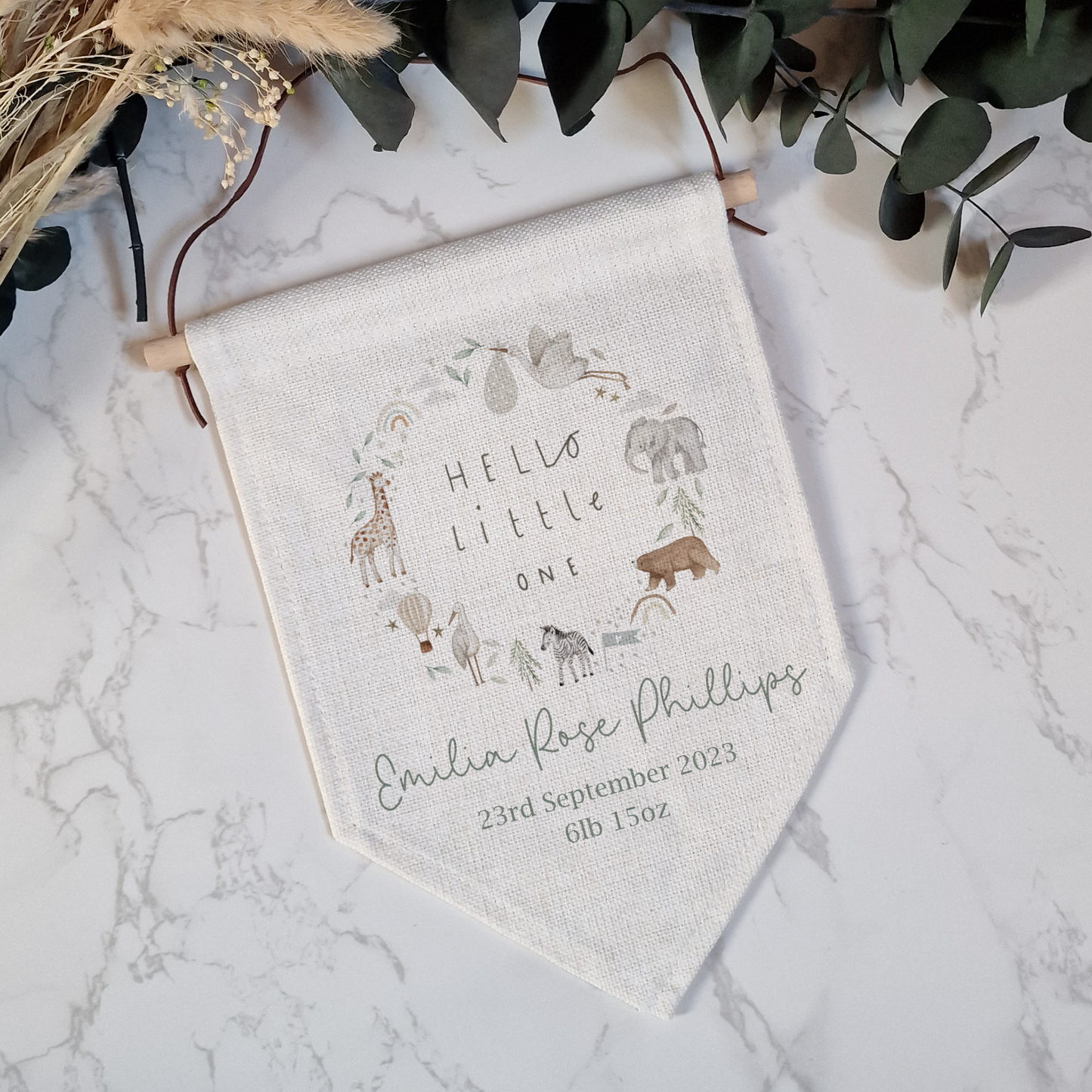 Off white linen flag with Hello Little One text and whimsical safari animals. Personalised with name and birth details in sage green font.