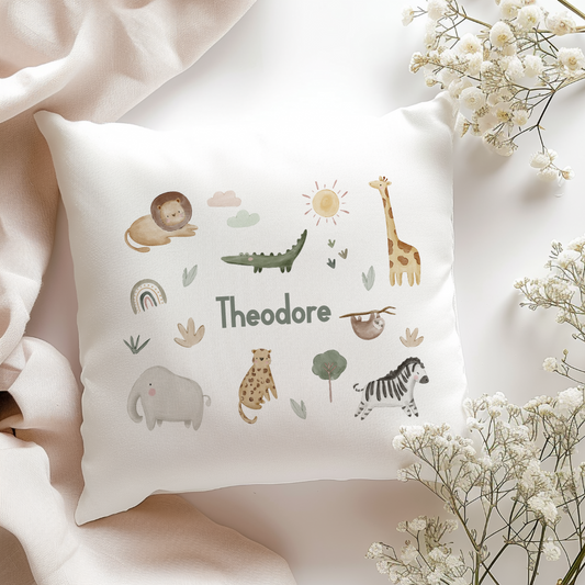 Decorative pillow with animal illustrations and the name 'Theodore' on a soft background.