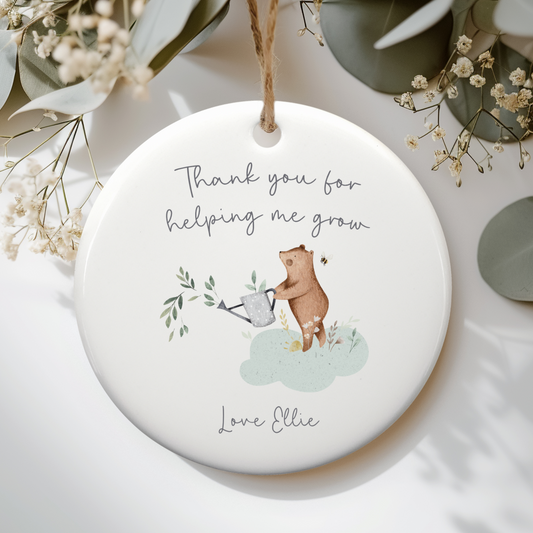 White ceramic ornament with cute bear with watering can illustration. Text includes "Thank you for helping me grow" and personalised with name.