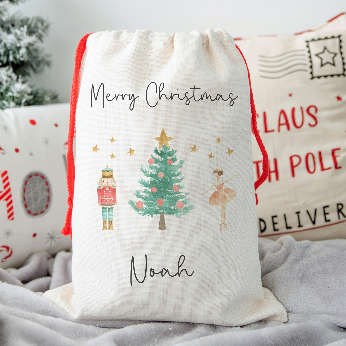 Off white linen like santa sack with sugar plum fairy and nutcracker toy soldier illustration. Personalised with name.