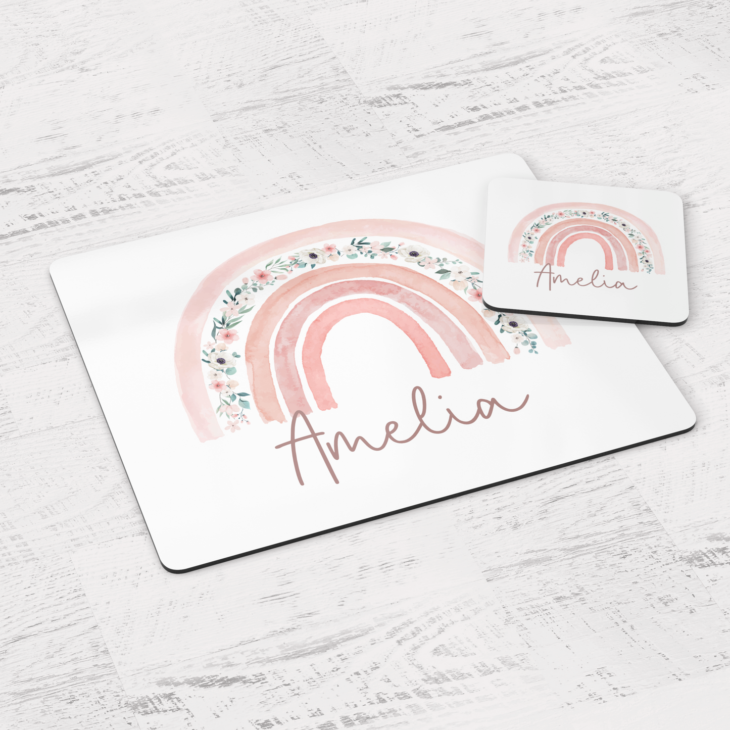 White placemat and coaster set with pink floral rainbow. Personalised with name in script font.