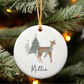 Decorative Christmas ornament with a deer design and 'Millie' text, hanging on a tree.