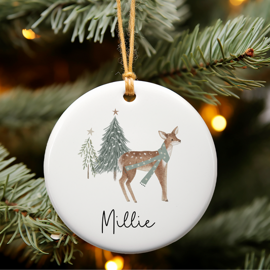 Decorative Christmas ornament with a deer design and 'Millie' text, hanging on a tree.