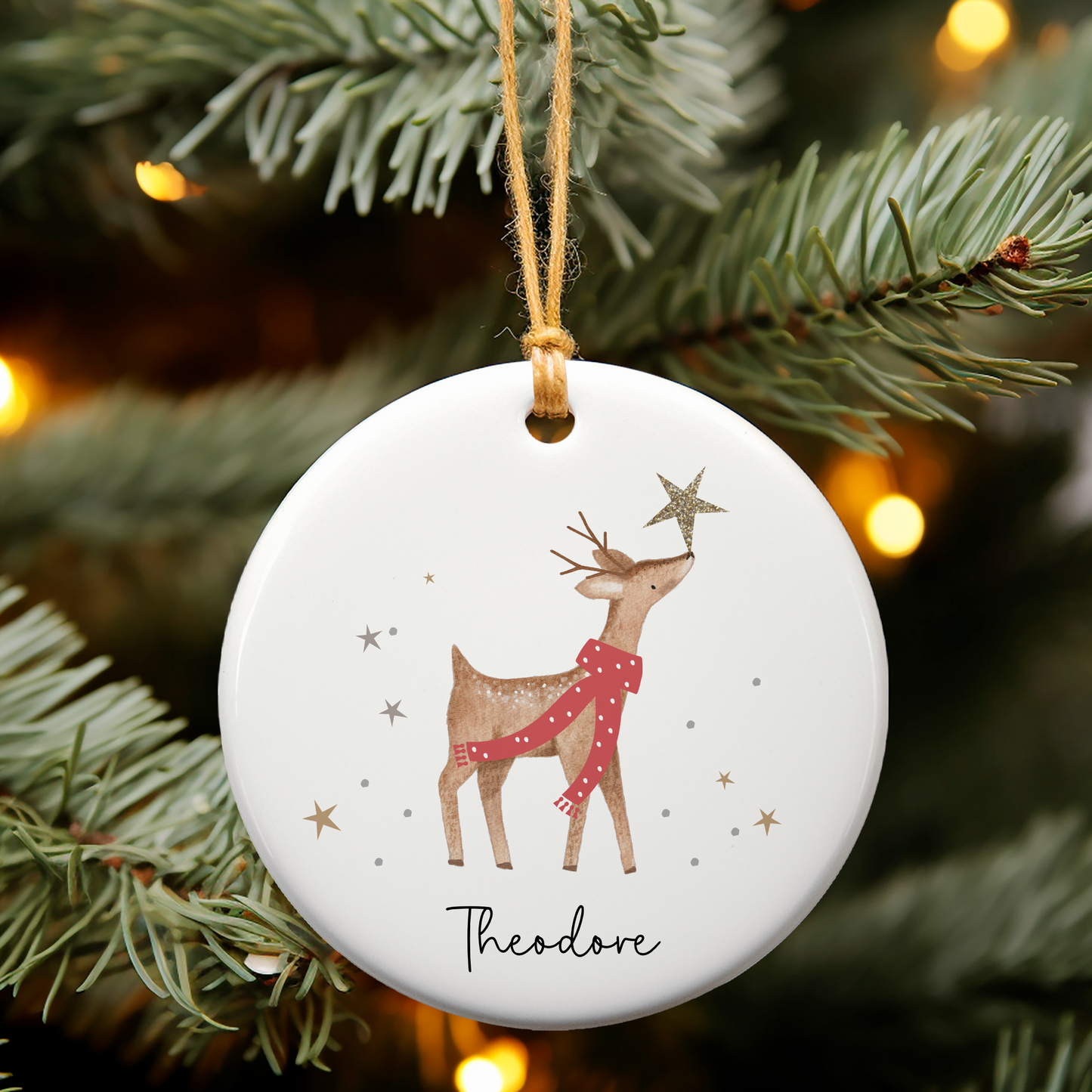 White ceramic Christmas ornament with magical reindeer and sparkly stars. Personalised with name in a handwritten font.