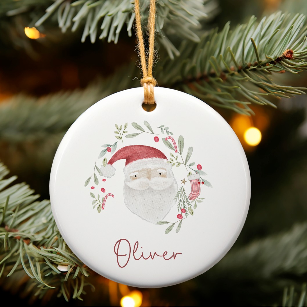 Christmas ornament with a Santa Claus design hanging on a tree.