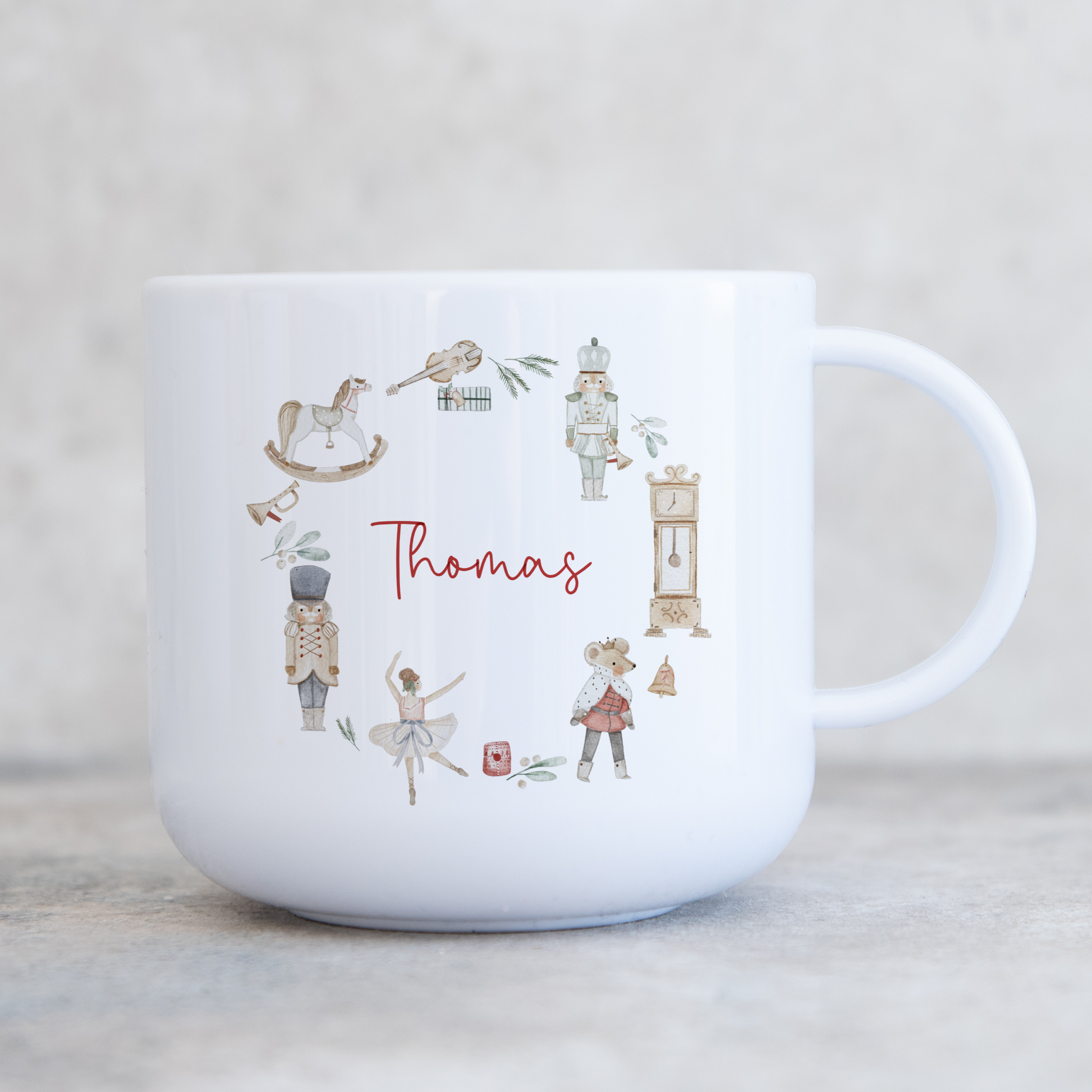 White polymer childs mug with traditional christmas illustration wreath. Personalised with name in red script font.