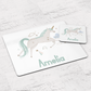 White placemat and set with unicorn with green tail. Personalised with name.