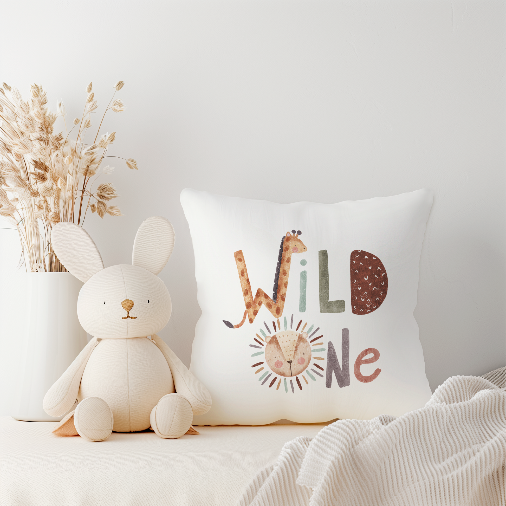 White cushion with wild one text incorporating giraffe and lion