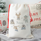 Off white linen santa sack, with red drawstrings on side. Wreath illustration of reindeer, polar bear, penguins and moose with name in the centre.