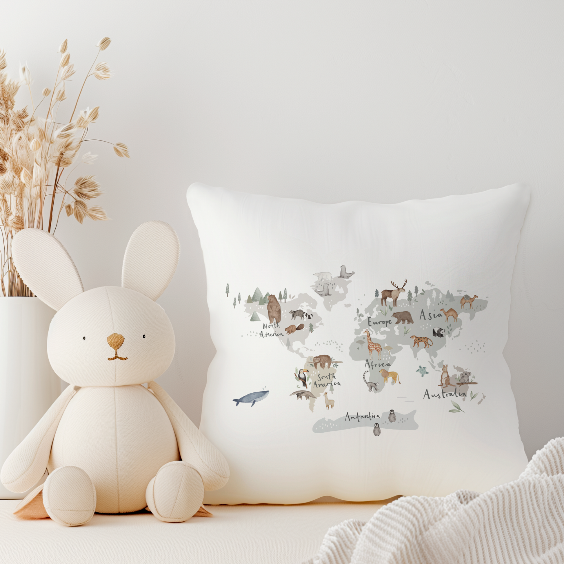 White canvas cushion with world map animals illustration.